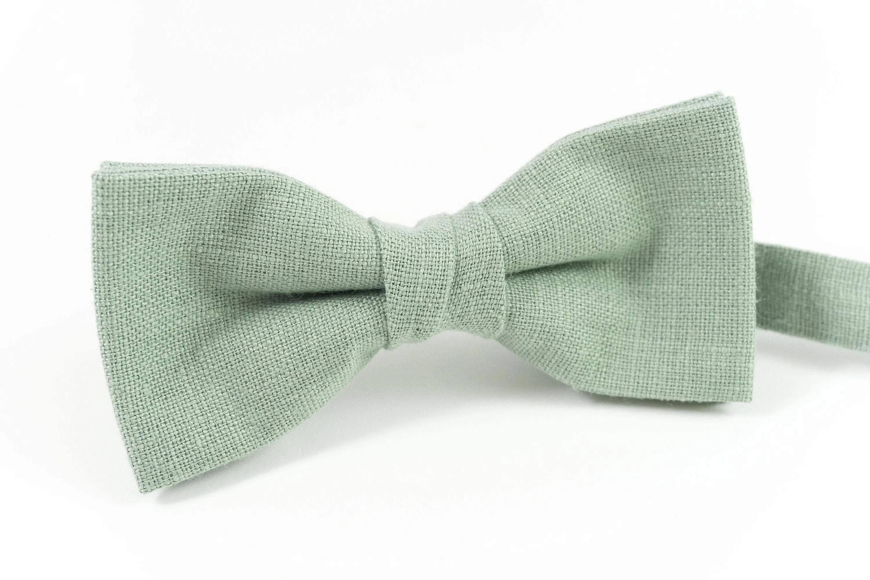 Dusty sage green adult bow tie attached to an adjustable strap